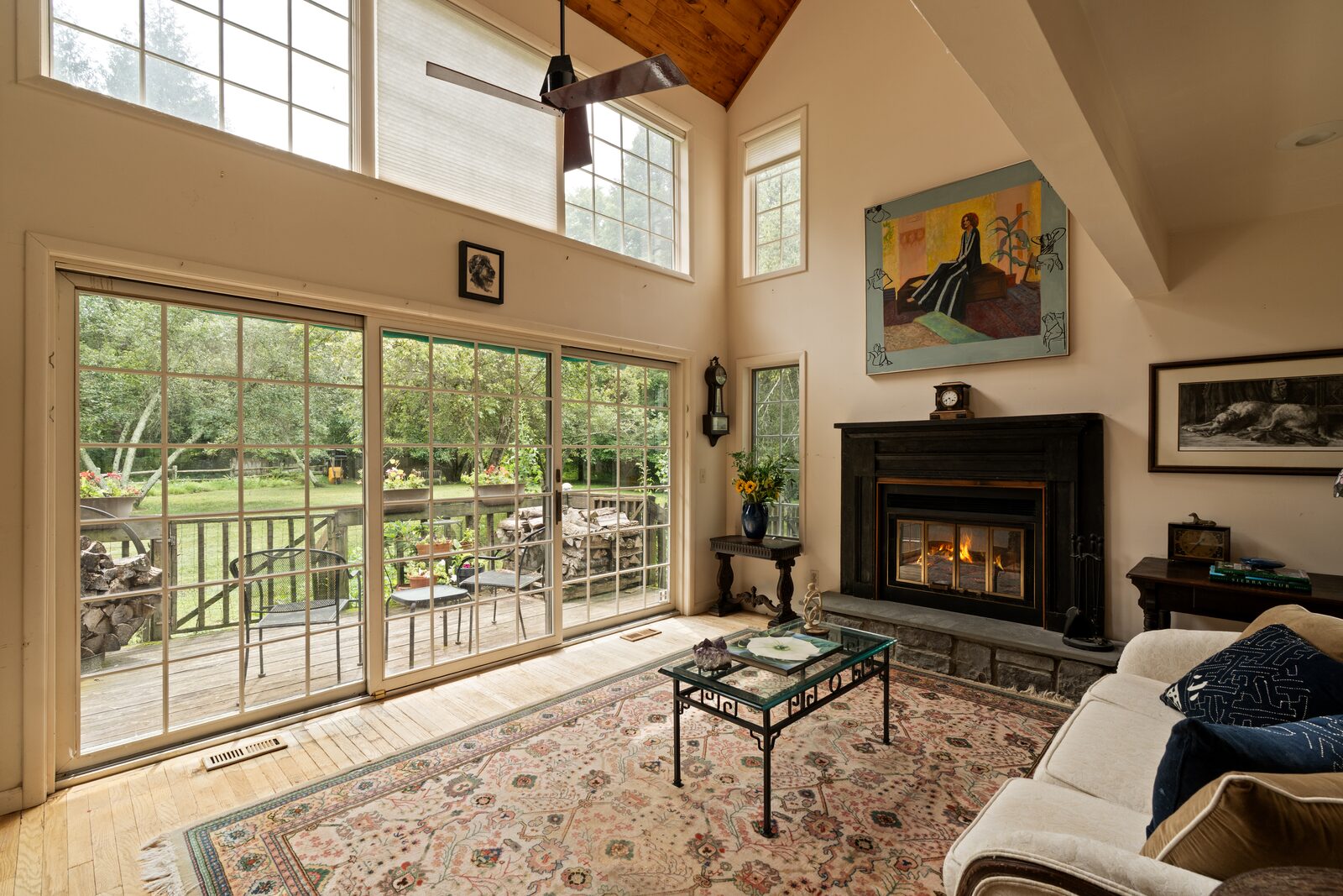 The great room — two stories to a vaulted ceiling, a wall of glass along one side, the fireplace holding the far end