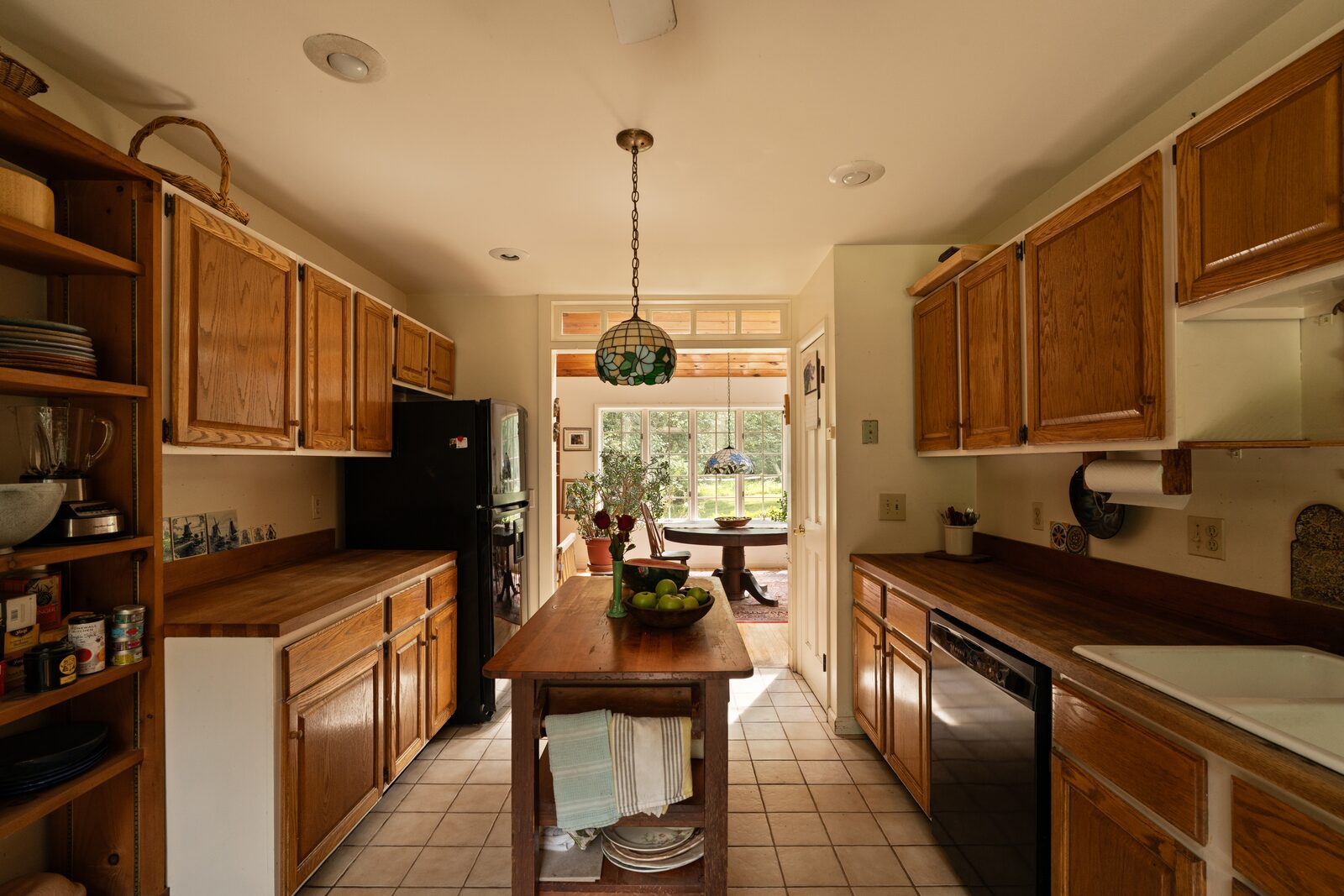 The kitchen island in butcher block, with a door standing open to the deck