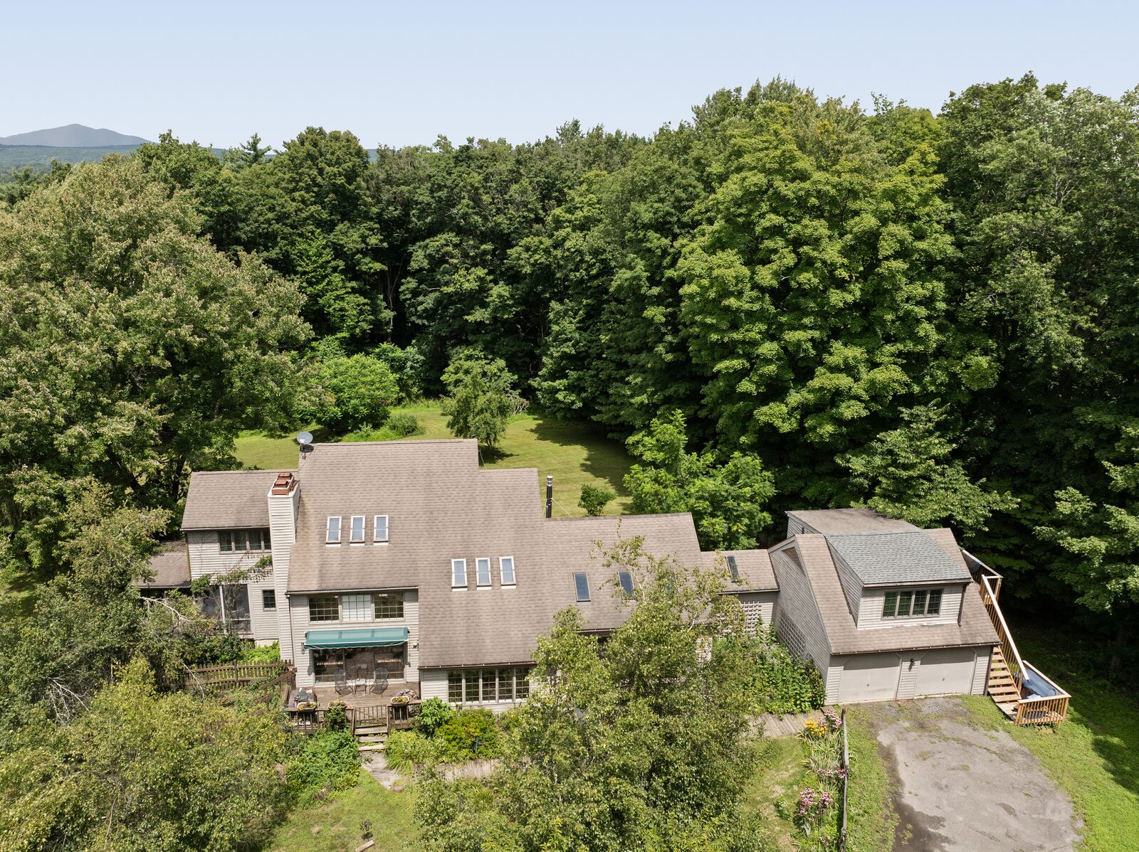 From the air — the house and garage set into unbroken canopy