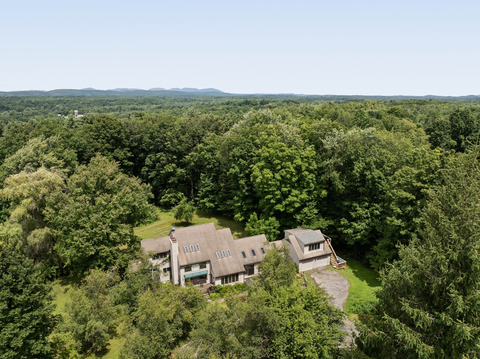 From the air — the clearing a small green interruption, the ridge across the horizon